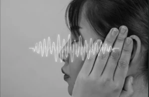 Femme ayant mal à l'oreille et cherchant des solutions pour diminuer ses acouphènes.