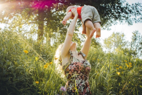 Jeune maman avec son bébé dans les bras qui est détendue et reposée après avoir utilisé régulièrement le pack de vidéos de relaxation dynamique et de lâcher prise à destination des mamans qui viennent d’avoir un enfant.