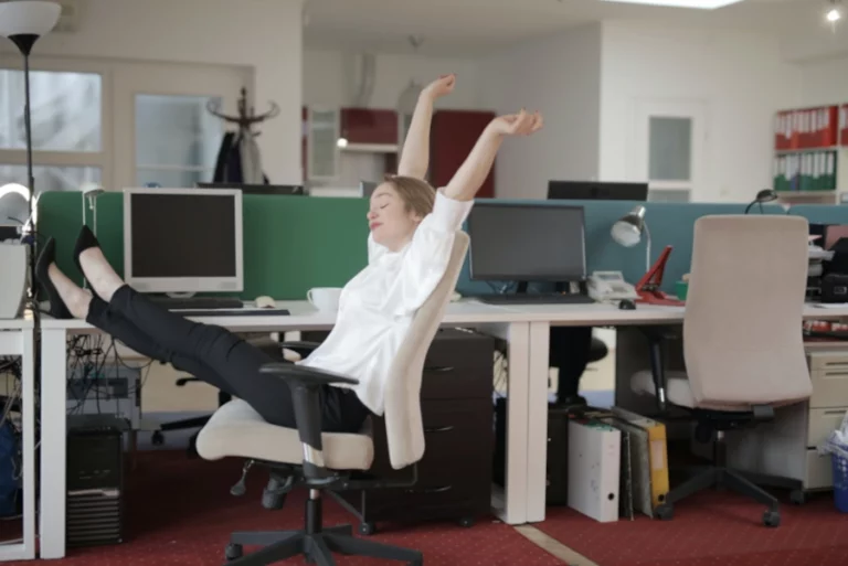 Femme au travail qui applique les étirements qu'elle a appris en sophrologie pour mieux gérer dans sa vie d'adulte.