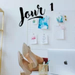 Femme derrière son ordinateur prenant le temps de faire une pause en s’étirant grâce à des vidéos de sophrologie en ligne.